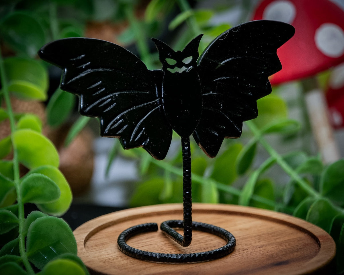 Black obsidian bat wing carvings on metal stand